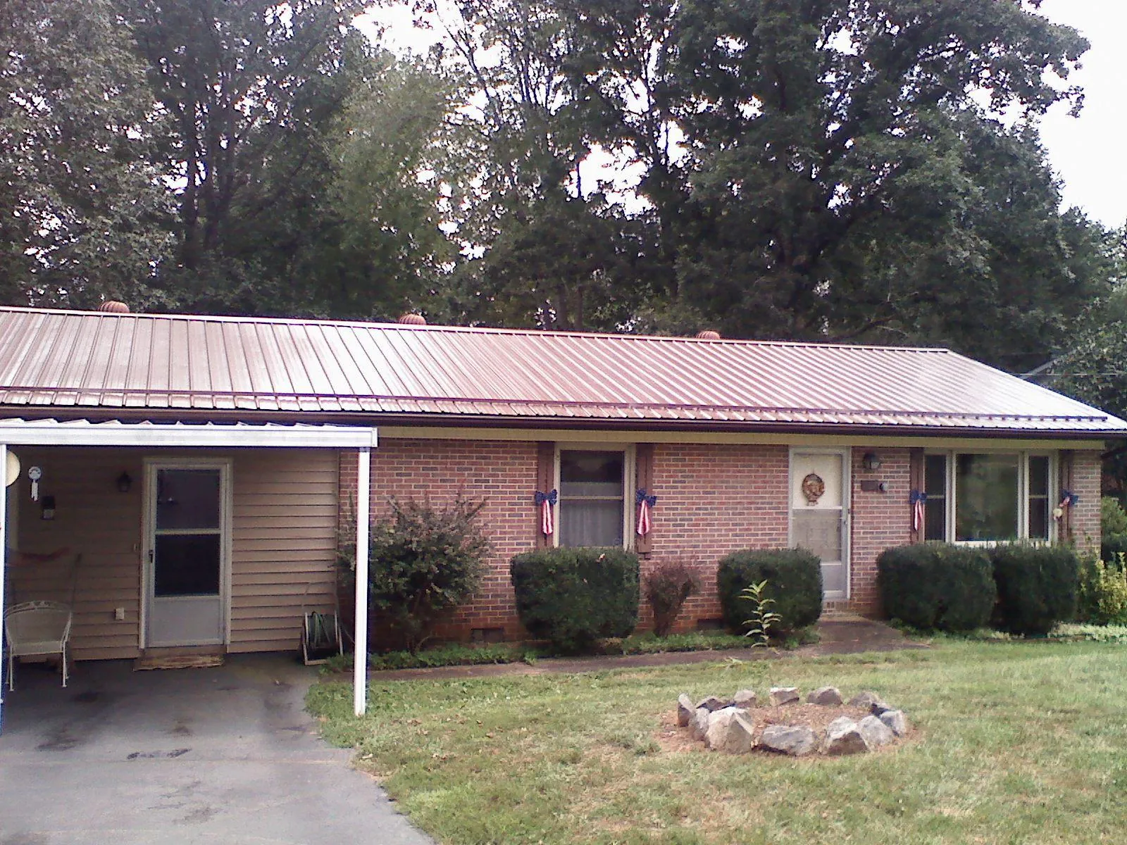 Bronze metal roof and carport on a brick ranch home — Roof Repair work by our crew in Wytheville